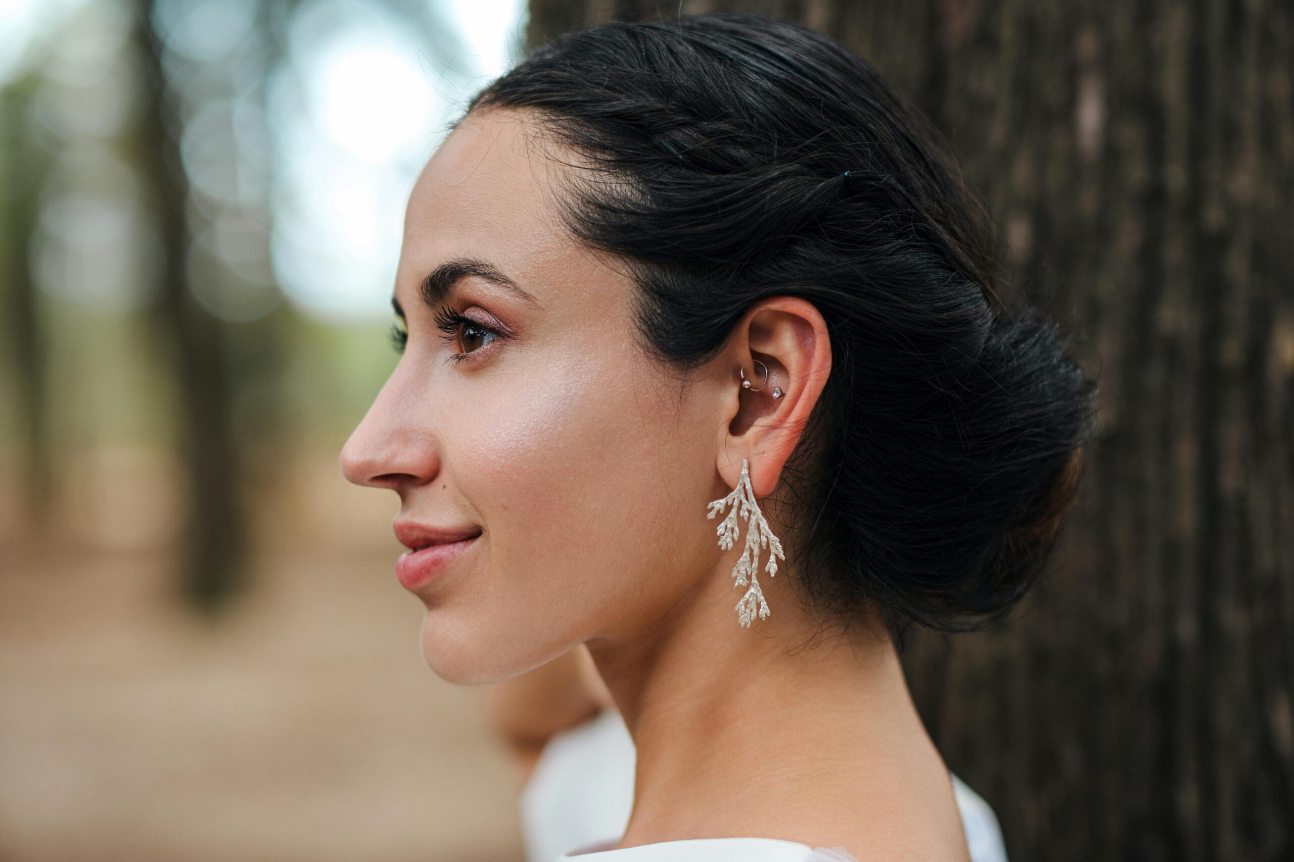 Side profile of a woman in Lisbon, showcasing elegant jewelry and fashion style.